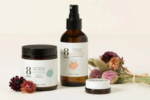 Herbal extracts for skin featuring a nourishing body butter and rosewater botanical hydrosol, surrounded by dried flowers.